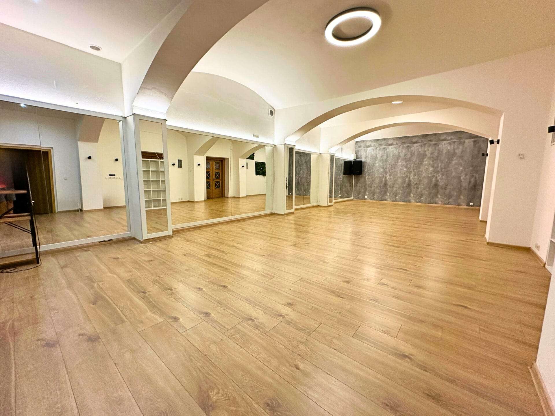 Taneční sál s kvalitním podlahovým pokrytím a minimalistickým designem Taneční sál s barevným osvětlením, ideální pro ruzne tance.